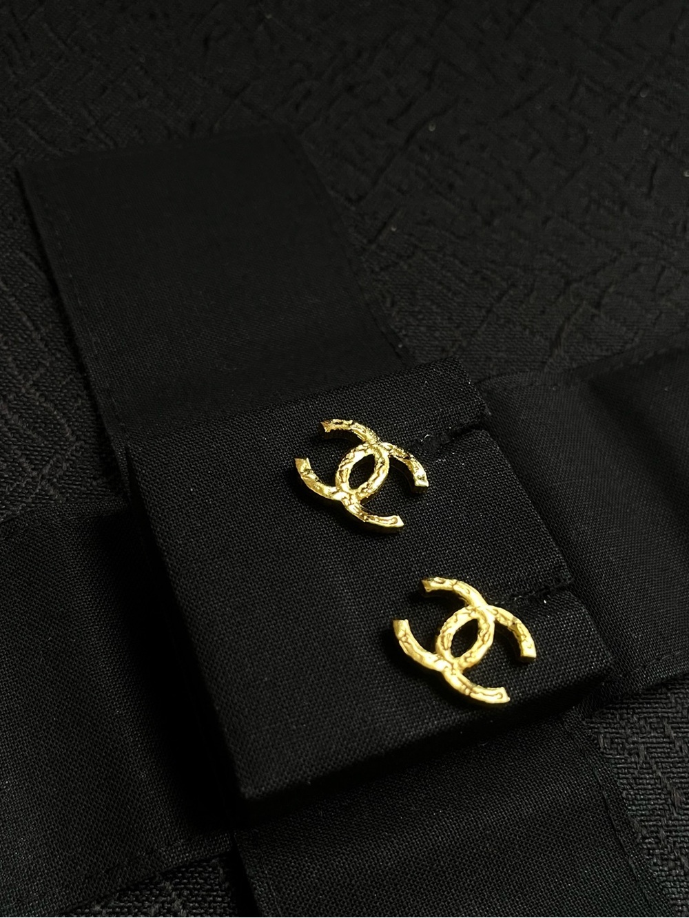 CHANEL Gold Interlocking CC Stud Earrings on Black